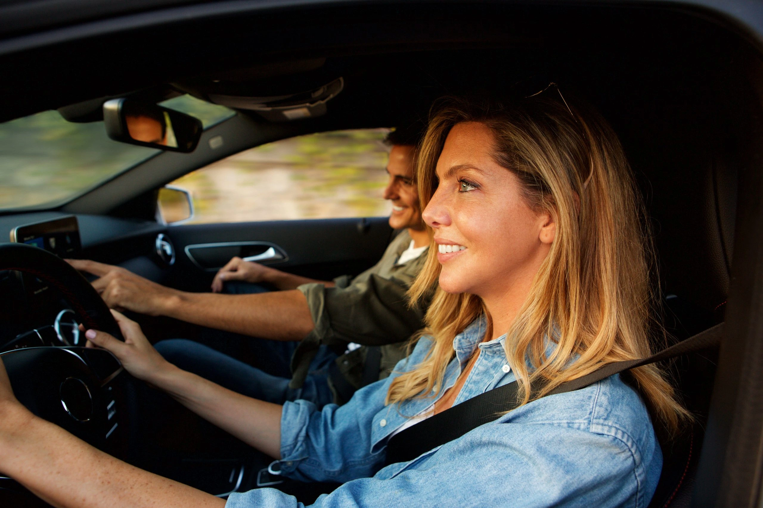Couple souriant en voiture pendant un trajet